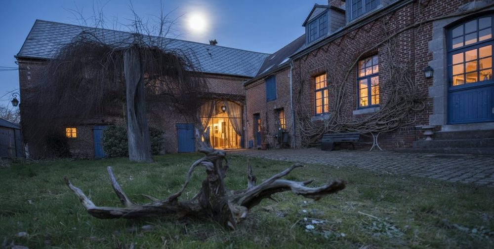 Les Granges de Béthencourt à la nuit tombée. Fenêtres éclairées, pleine lune au-dessus du toit.