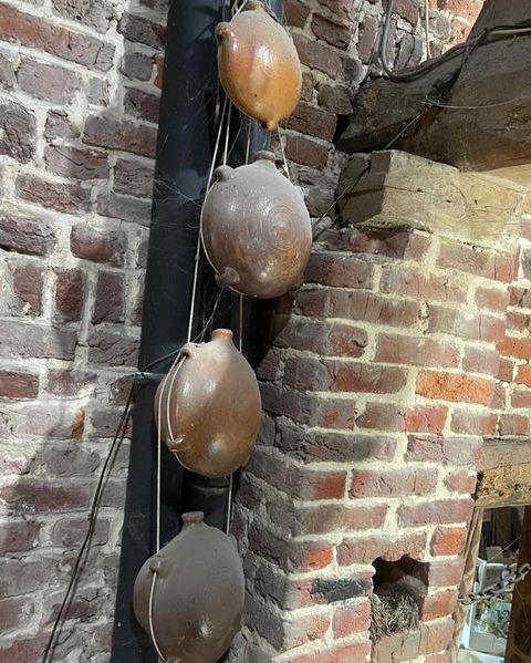 Des objets anciens accrochés au mur de brique