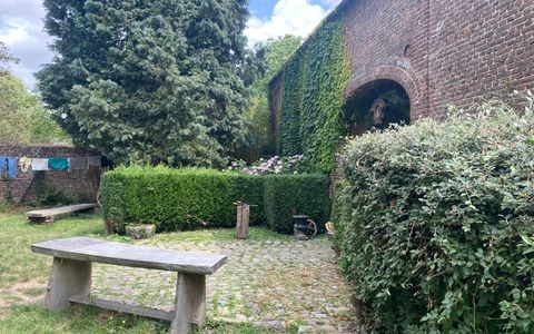 Le banc de pierre dans la cour, entre les haies